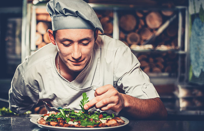 Chef garnishing a gourmet meal plate