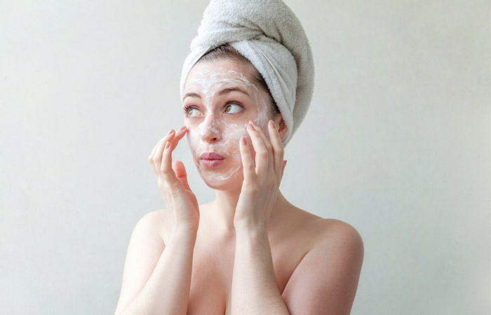 Woman cleanses her face to prevent large pores.