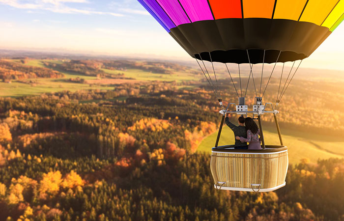 Couple air-ballooning over forests