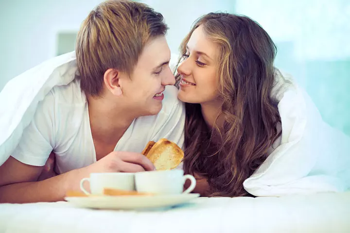 Couple eating breakfast together in bed
