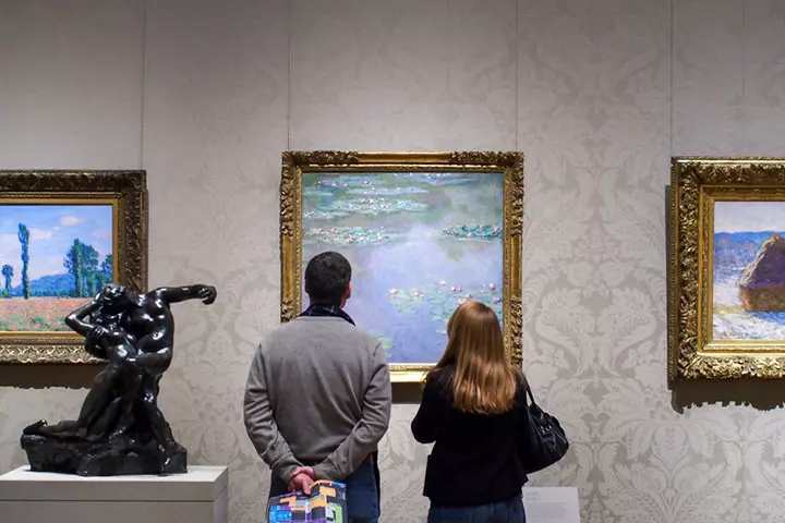 Couple in a museum viewing paintings