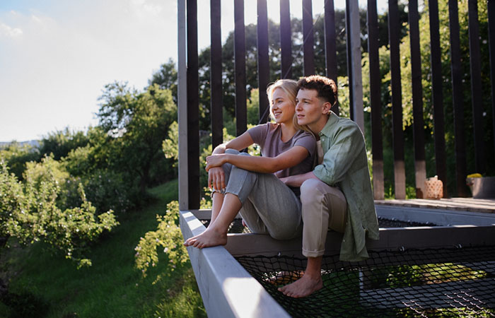 Couple sitting outside a cabin surrounded by nature