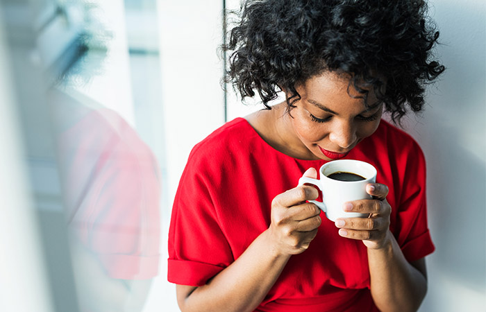 Woman drinking black coffee to improve skin elasticity