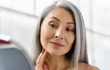 Woman looking at her glowing skin after a change in food intake