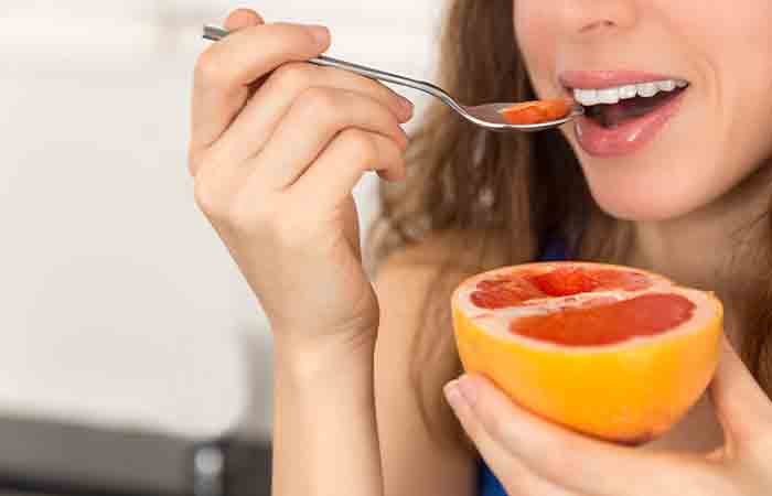 Woman eating grapefruit with a spoon