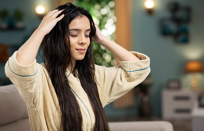 Woman massaging her hair with soybean oil for deep conditioning