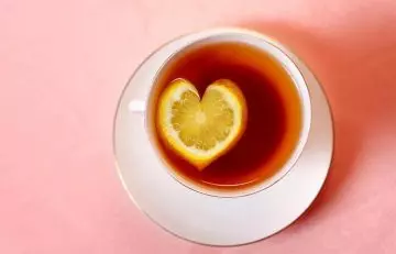 Heart shaped lemon slice in lemon tea to emphasize improved heart health from Vitamin C in it