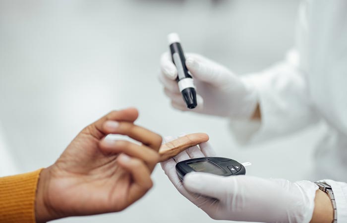 Closeup of a healthcare expert checking blood glucose test of a woman