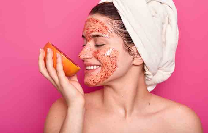 Woman with grapefruit mask on her face