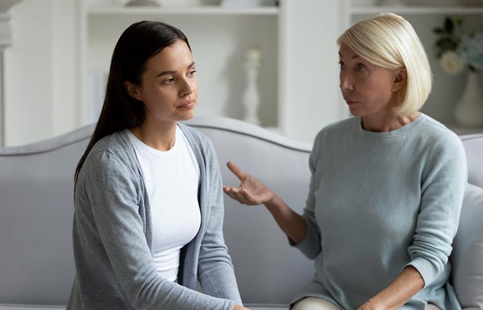 Woman looks exhausted while talking to an older woman