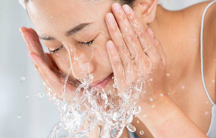 Woman washing face with cold water to achieve beautiful skin