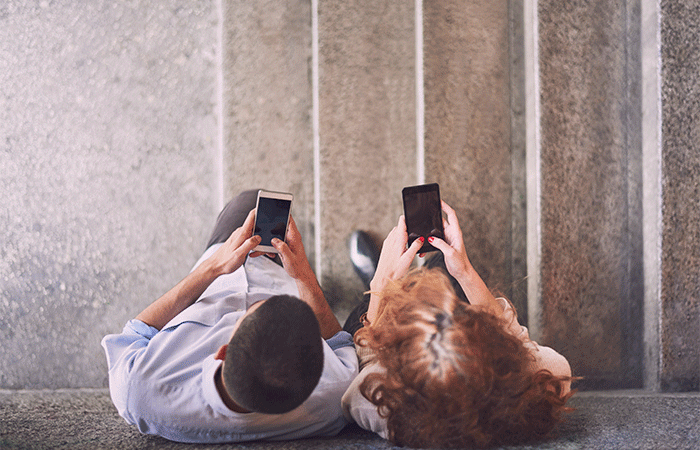 An upper view of a couple texting each other