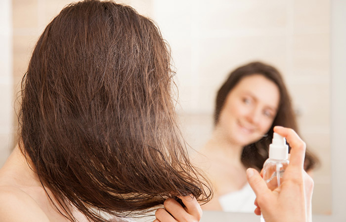 Woman applying Epsom salt spray on hair