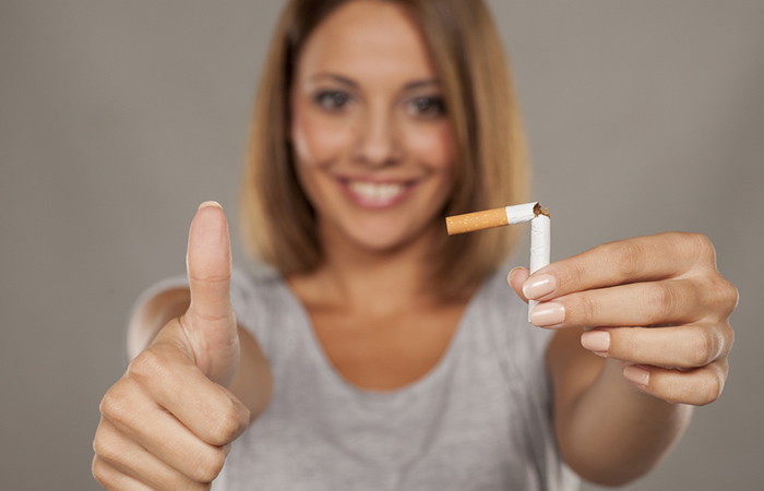 Woman quitting smoking by breaking a cigarette to achieve beautiful skin