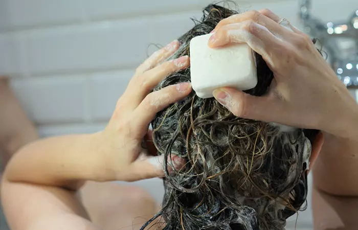 Woman washing her hair with a shampoo bar.