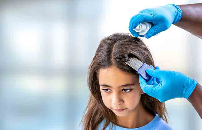 Woman treating daughter's lice with tea tree oil