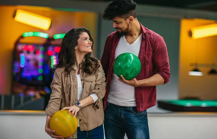 Couple holding bowling balls