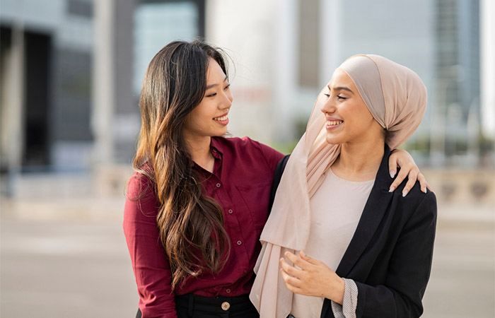 Women of two different cultures embrace as friends