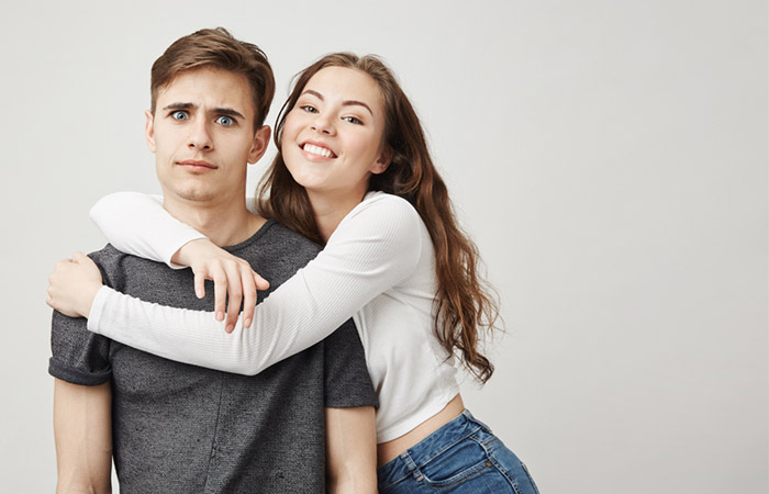 Man looks uncomfortable as his partner with an anxious attachment style clings to him