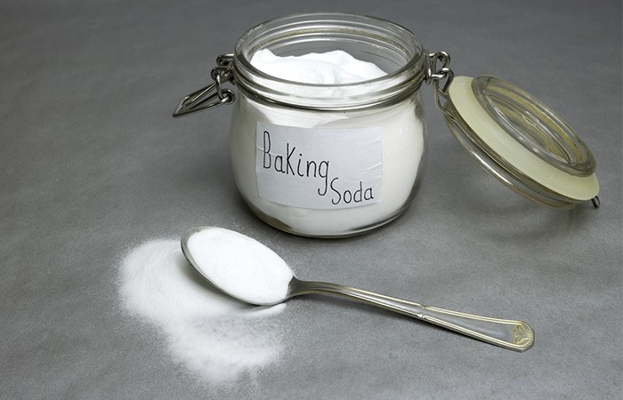 A container of baking soda on gray background