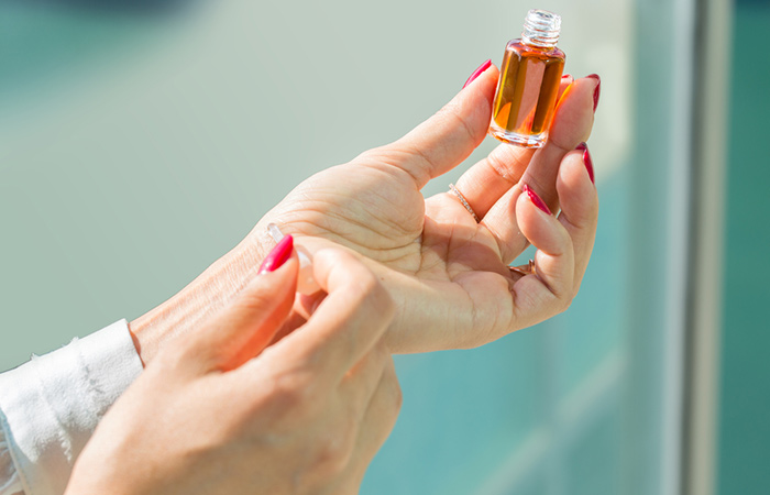 Woman performing a patch test with an essential oil on her wrist