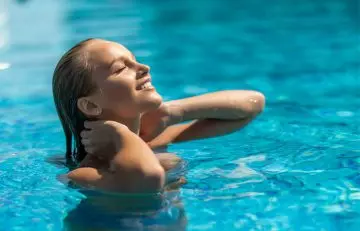 Woman in swimming pool for fading fake tan