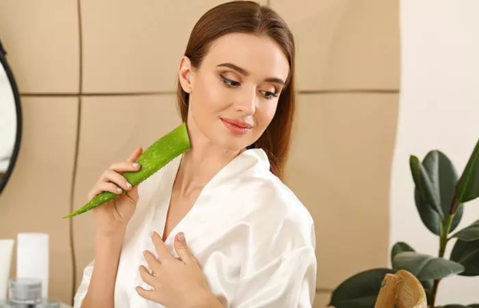 Woman applying fresh aloe vera gel to her skin