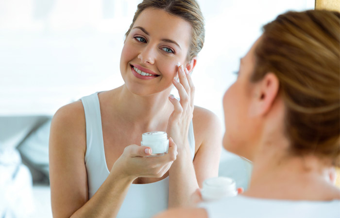 Woman applying amino acid-rich facial cream