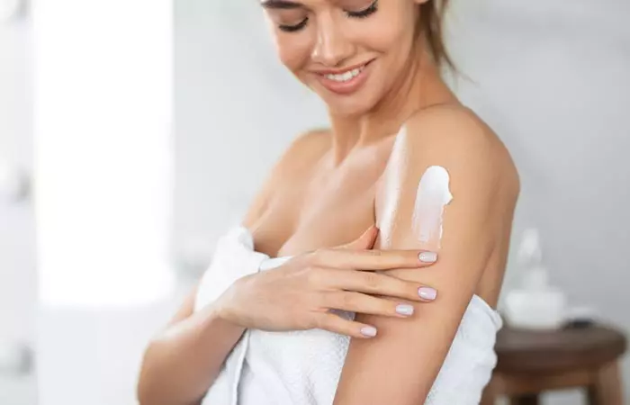 Woman using body cream containing isoparaffin.