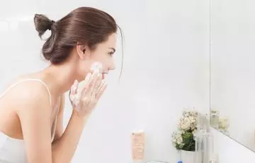 Woman washing her face to prevent nodular acne