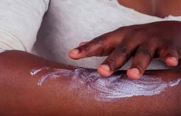 Woman applying toothpaste to remove fake tan