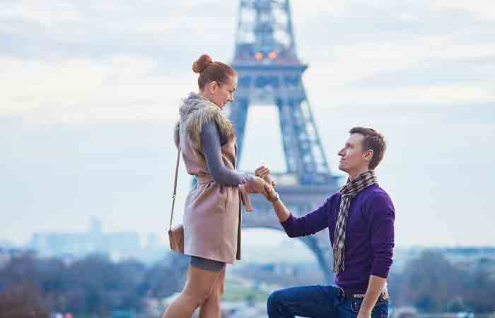 A man proposing and committing to his lady love in front of Eiffel tower. 