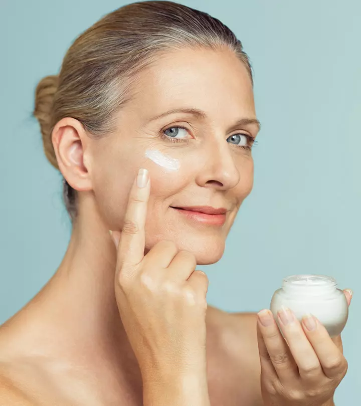 A girl holds a retinol and retinoid bottles