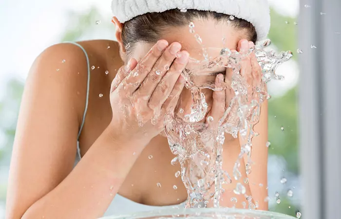 Woman splashing water on her face during her wash