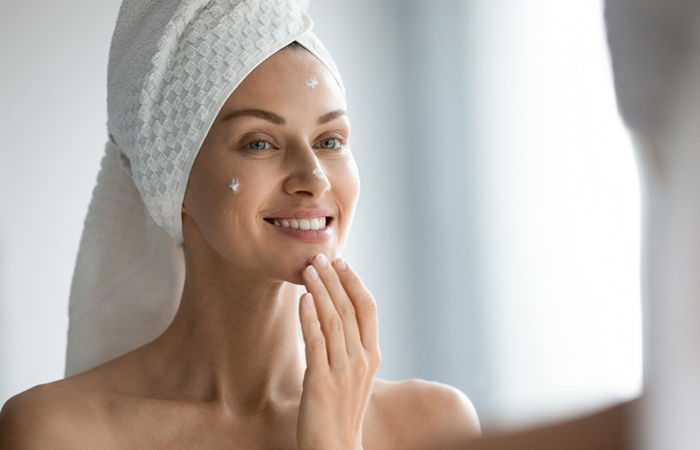 Woman moisturizing her skin to avoid dry skin around mouth