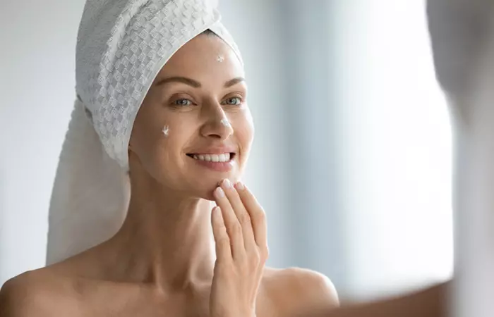 Woman moisturizing her skin to avoid dry skin around mouth