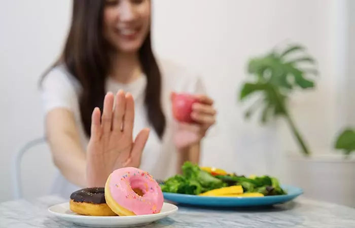 Woman choosing vegetables over high GI foods