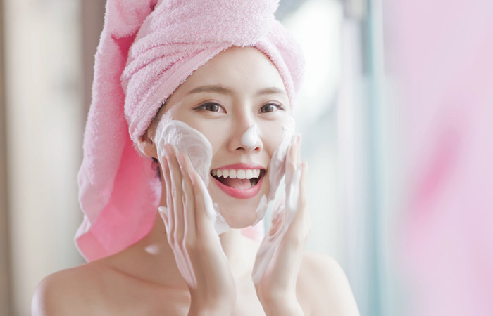 Woman using a lathering face wash.