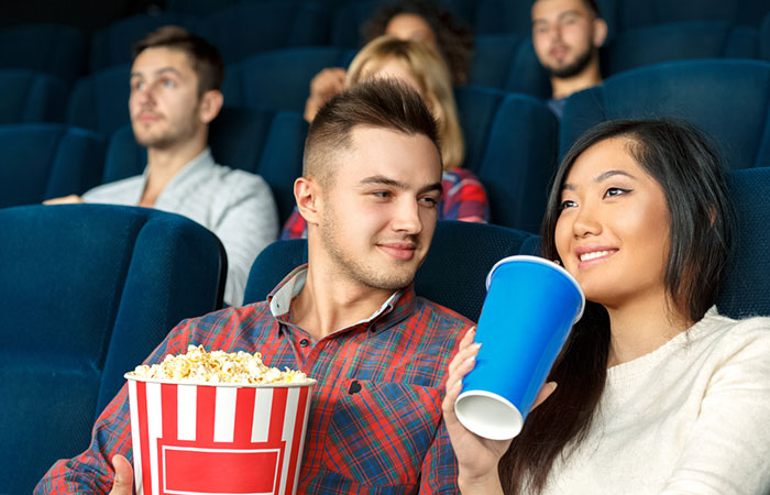 Man looking at his partner lovingly in a movie theatre