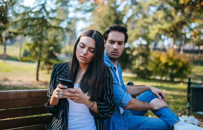 Jealous man checking who his partner is talking to