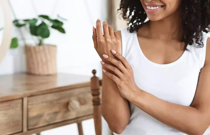 Woman applying propylene glycol-based cream on her arm