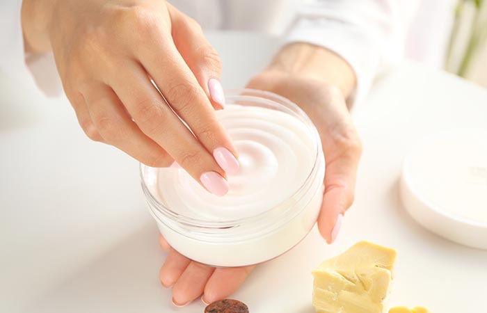 Woman using cocoa butter cream for skin