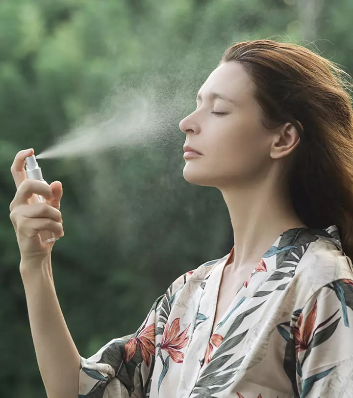 A girl is spraying thermal water on her face