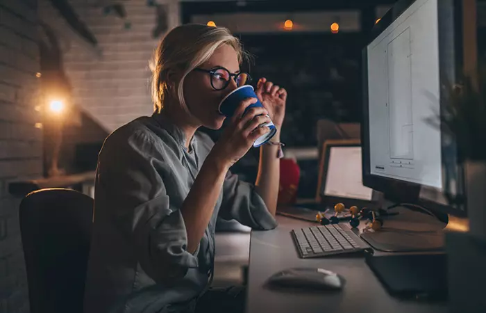 Busy woman working late into the night and drinking coffee