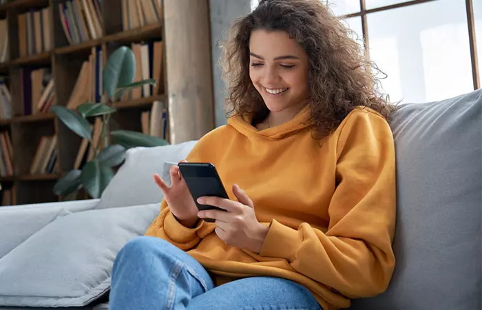 Girl sending a text with a smile