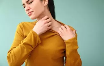 Woman itching after applying tea tree oil for skin tags