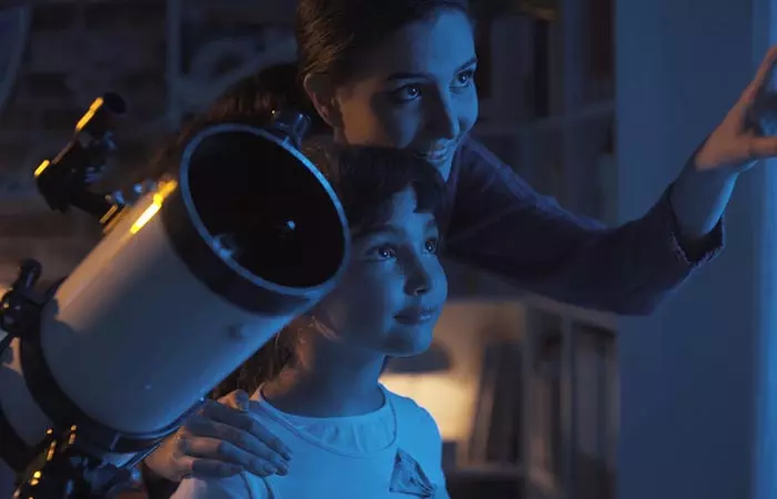 A mother is pointing at the night sky to show her child the stars.