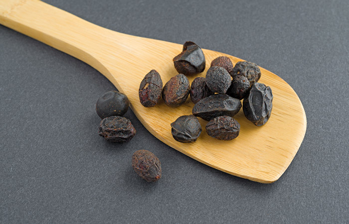 Saw palmetto berries for acne on a wooden spatula