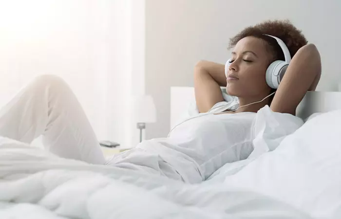 African woman relaxing and listening to music