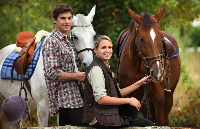 A young couple learning horse riding.